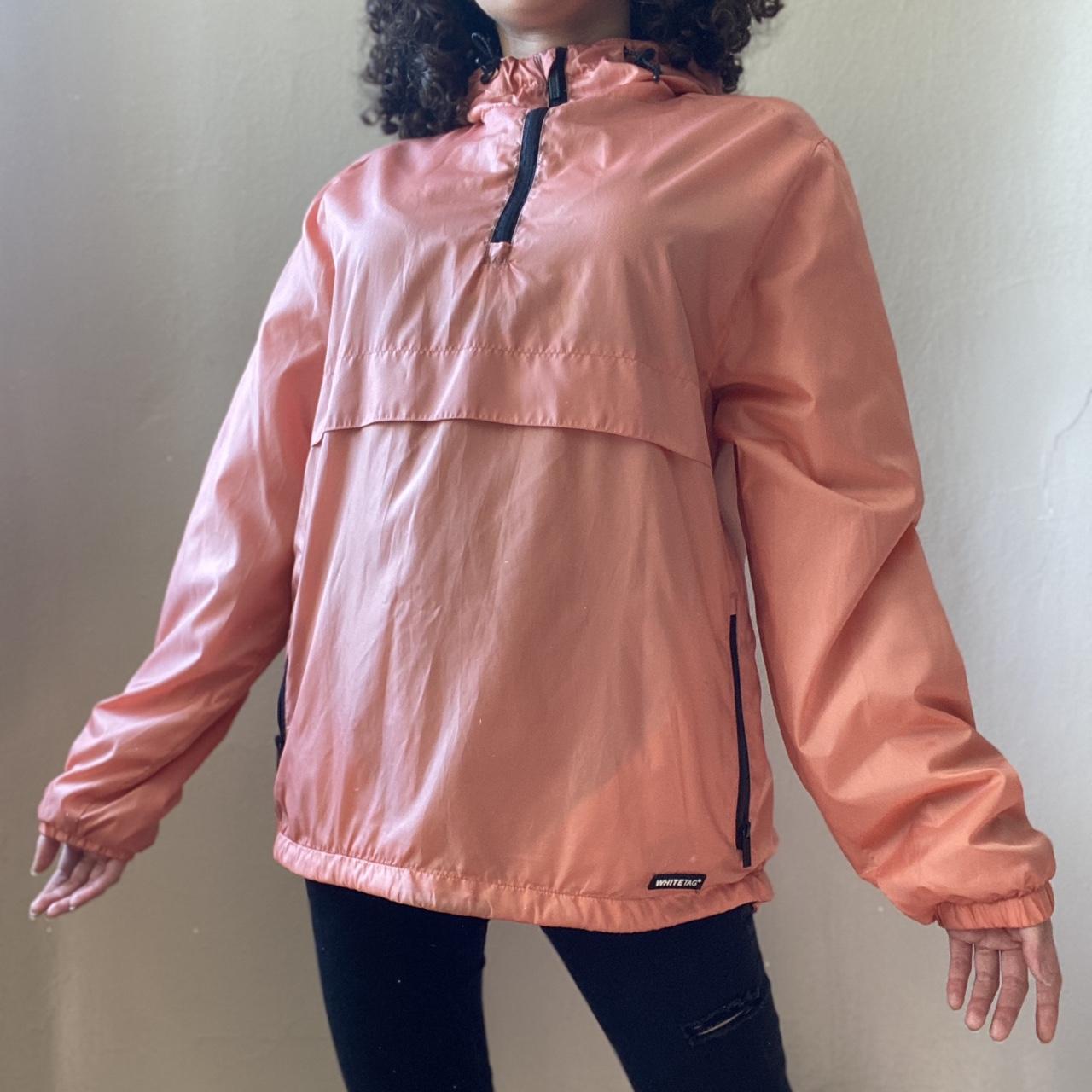 A salmon pink half zip windbreaker by the brand