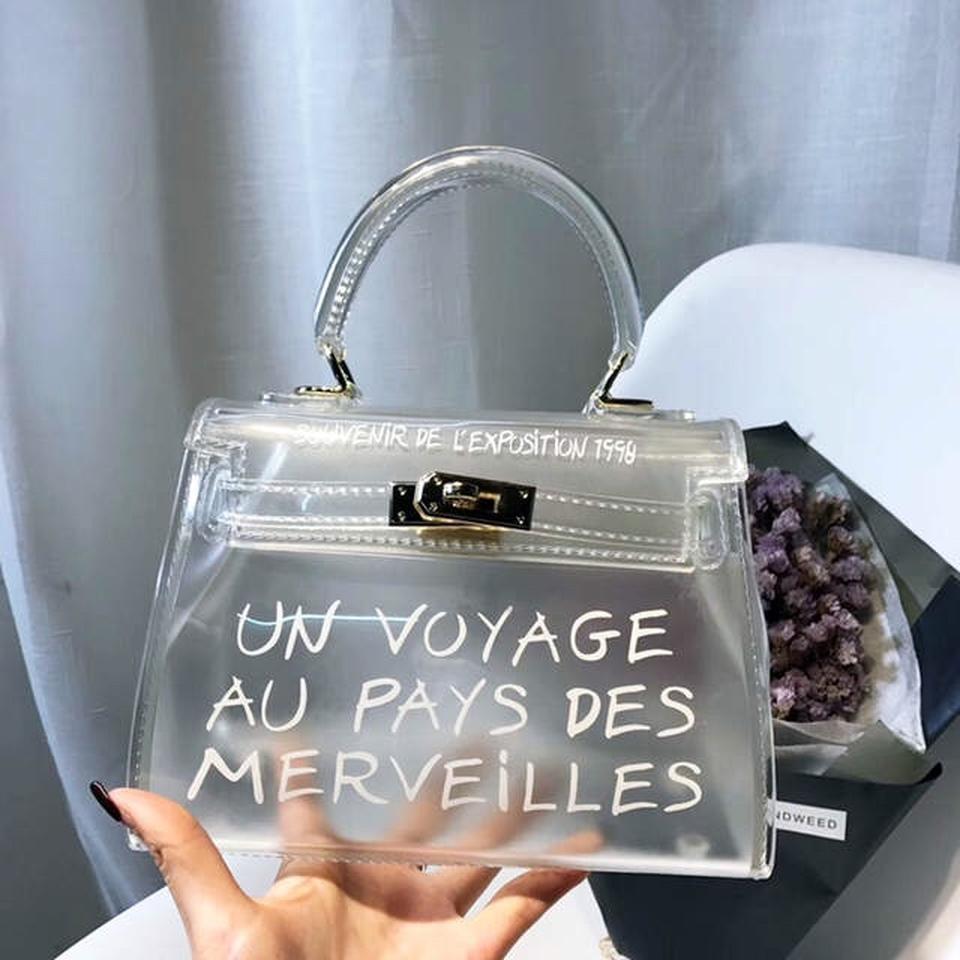 Un Voyage Paris Petite bag Clear bag with gold Depop