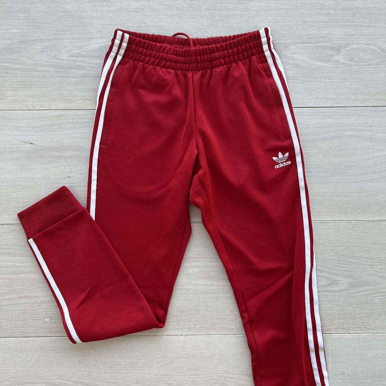 Red Adidas track pants with custom embroidery