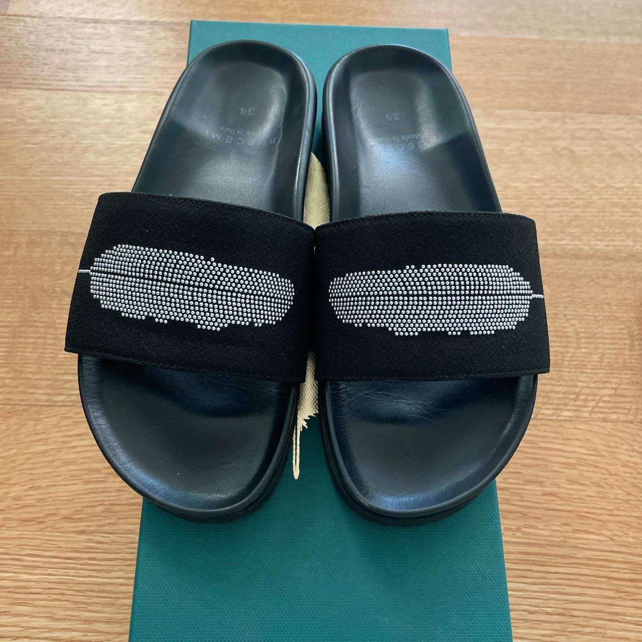 Buscemi black slides with a feather shape at the top