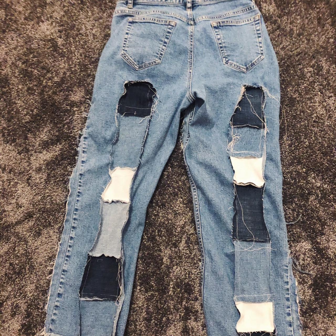 Custom design of blue denim jeans with ripped knees and patches on Craiyon