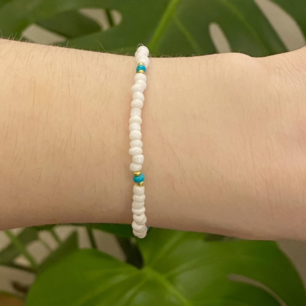 White handmade beaded bracelet on an elastic cord... - Depop