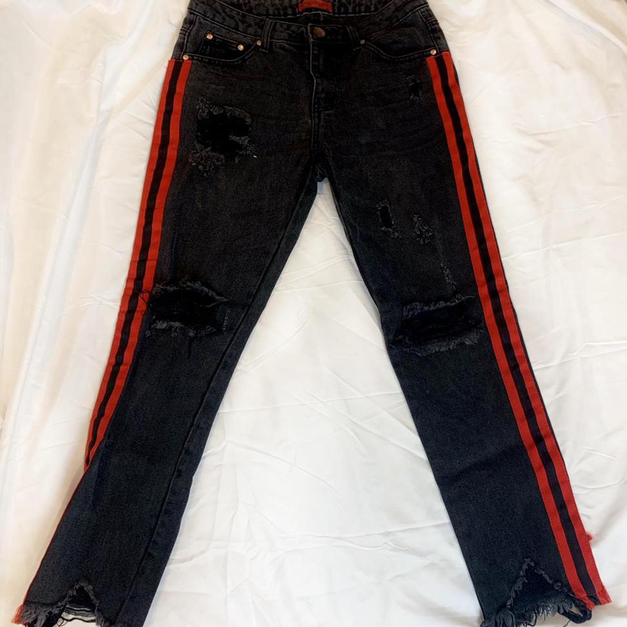 Faded black ripped jeans with red stripes on side... - Depop