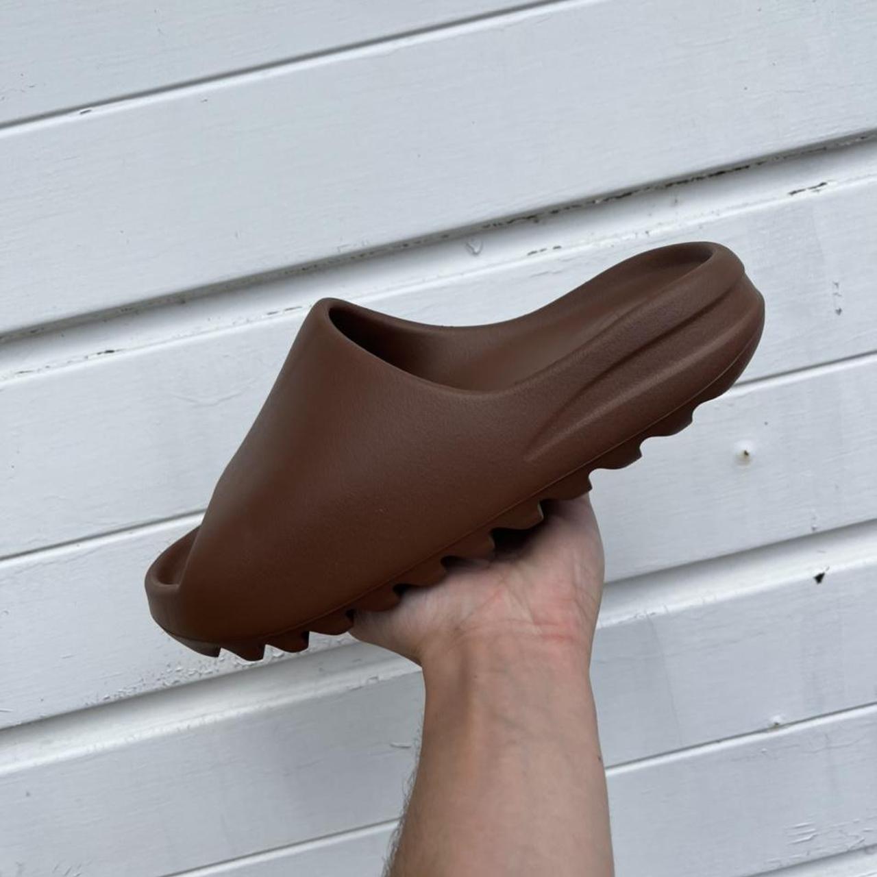 earth brown yeezy slides on feet