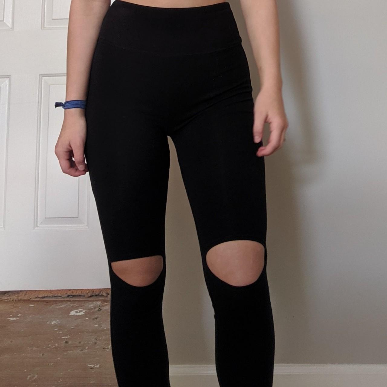 Black long leggings with holes in the knees. They