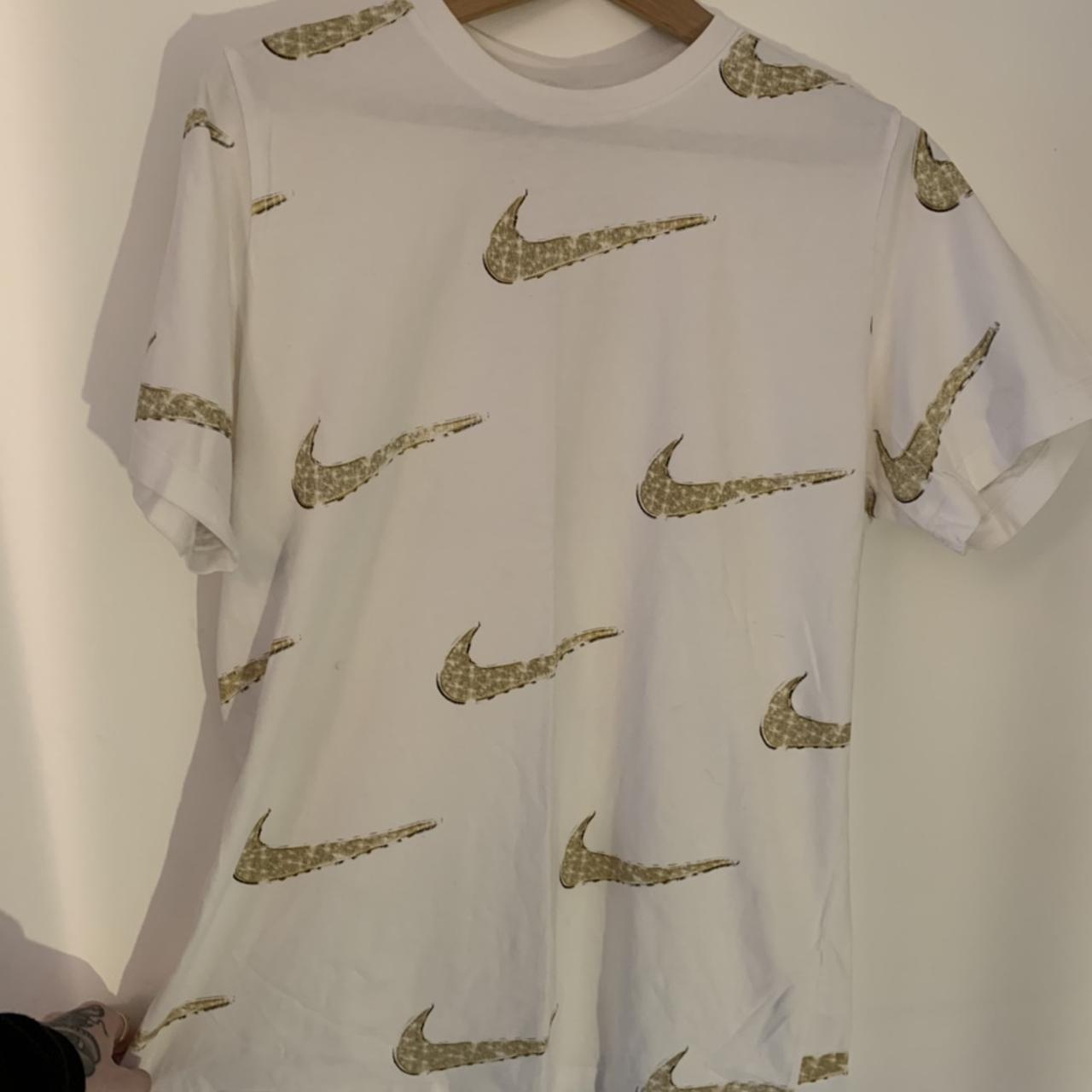 white nike shirt with gold swoosh