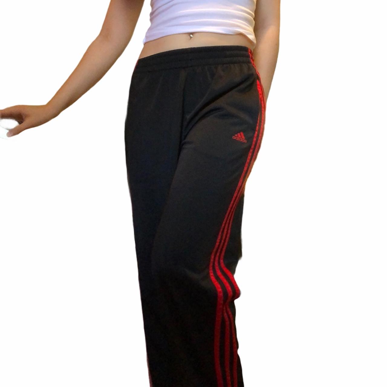Black Adidas track pants with red stripes on the... Depop