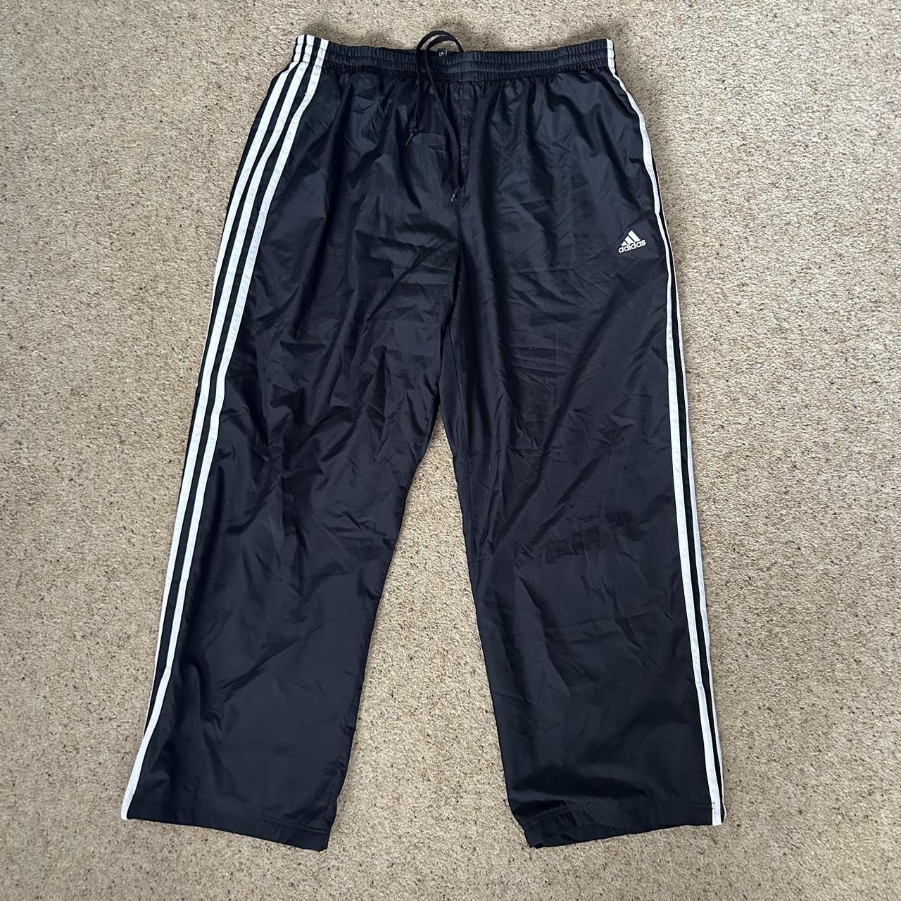 Black adidas tracksuit bottoms with white stripes as... - Depop