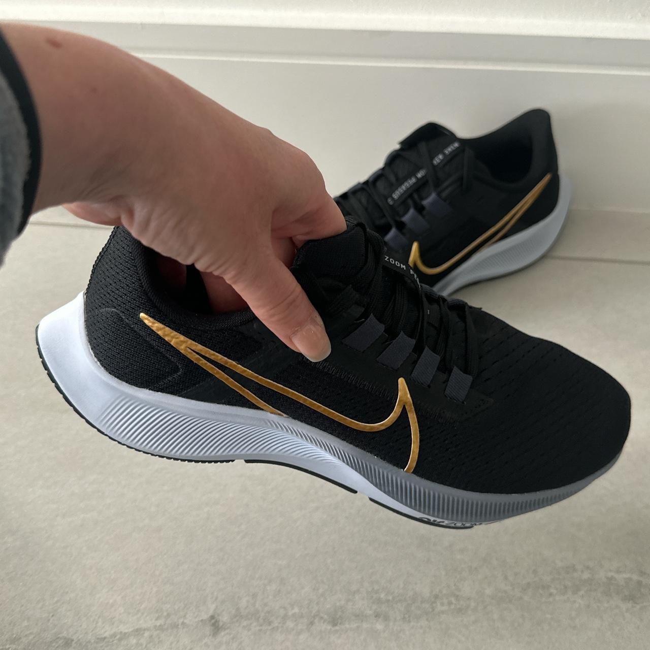 Gold and 2025 black nike trainers