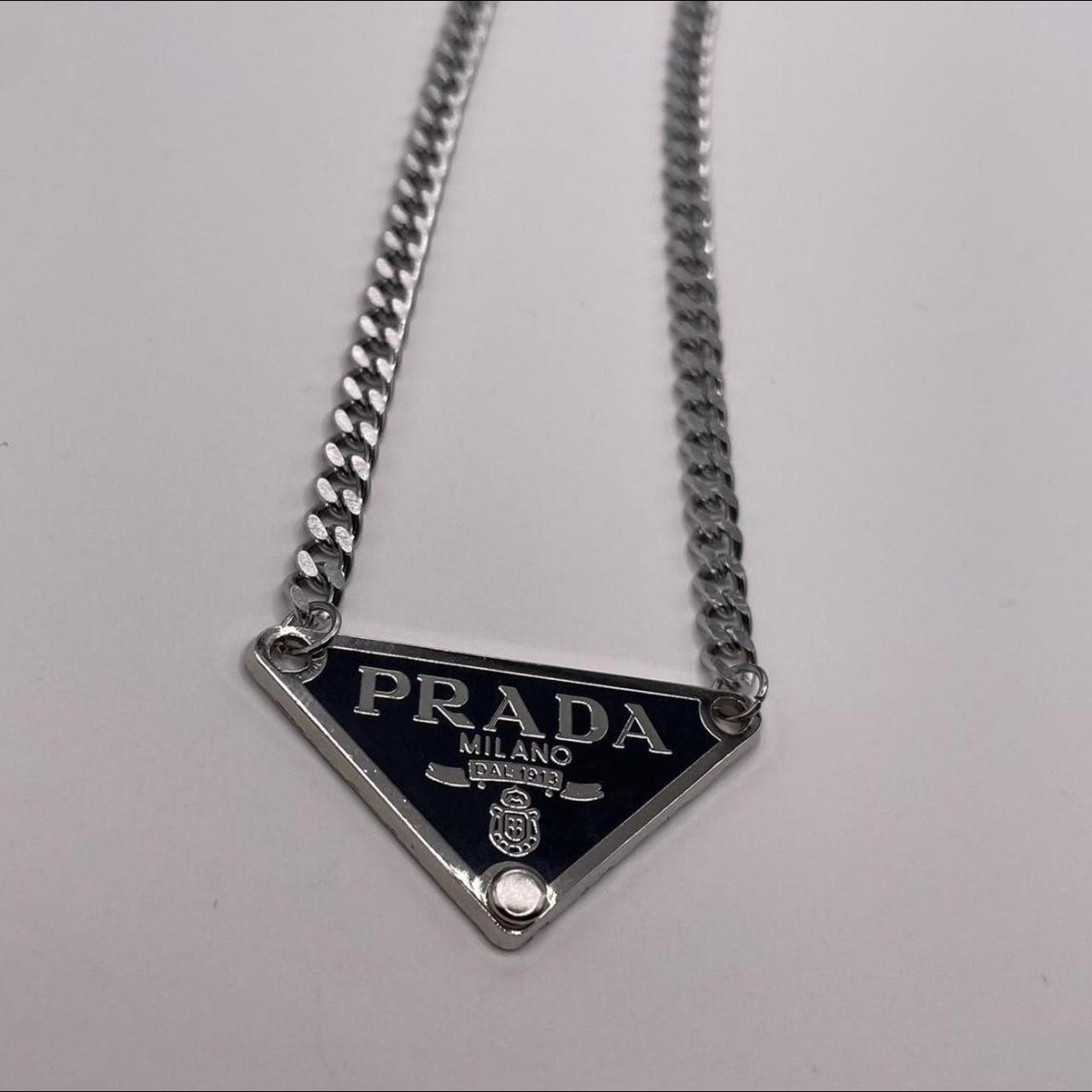 Y2k Prada Silver pendant necklace placed on a silver... - Depop