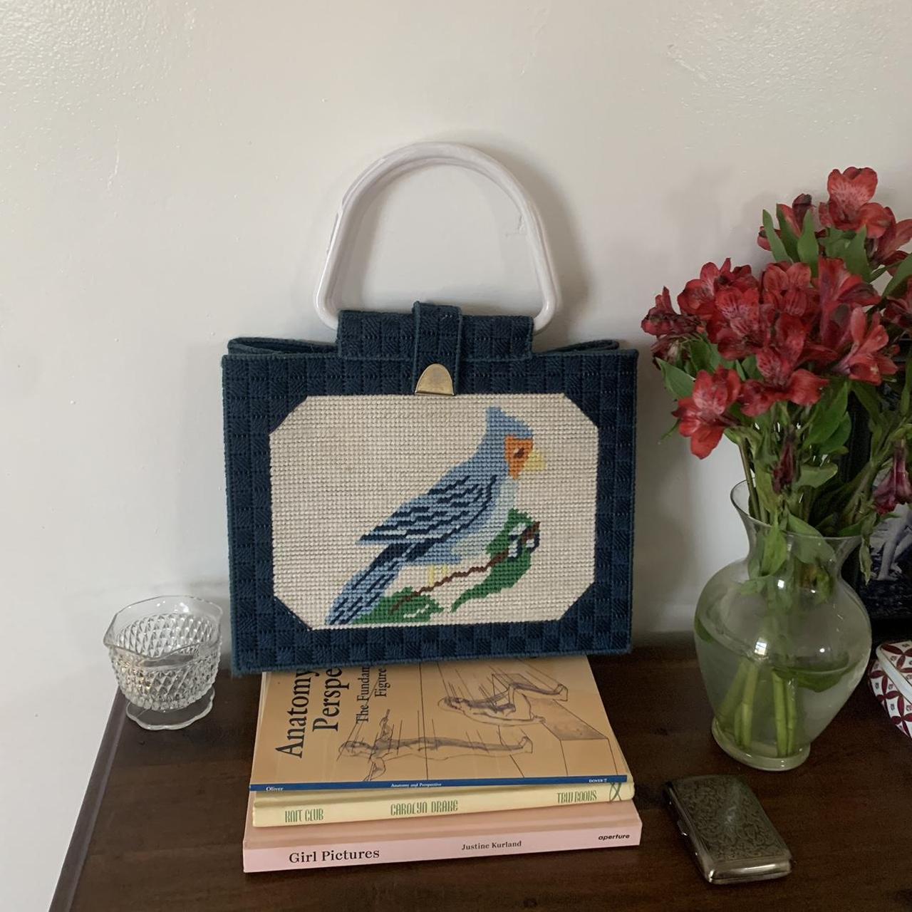 Purse. Ladies' bag of white moiré silk embroidered in colored silks. Shape  is five-sided, flat, with a scalloped top. Borders of flower wreaths.  Embroidered on one side with a greyhound and with