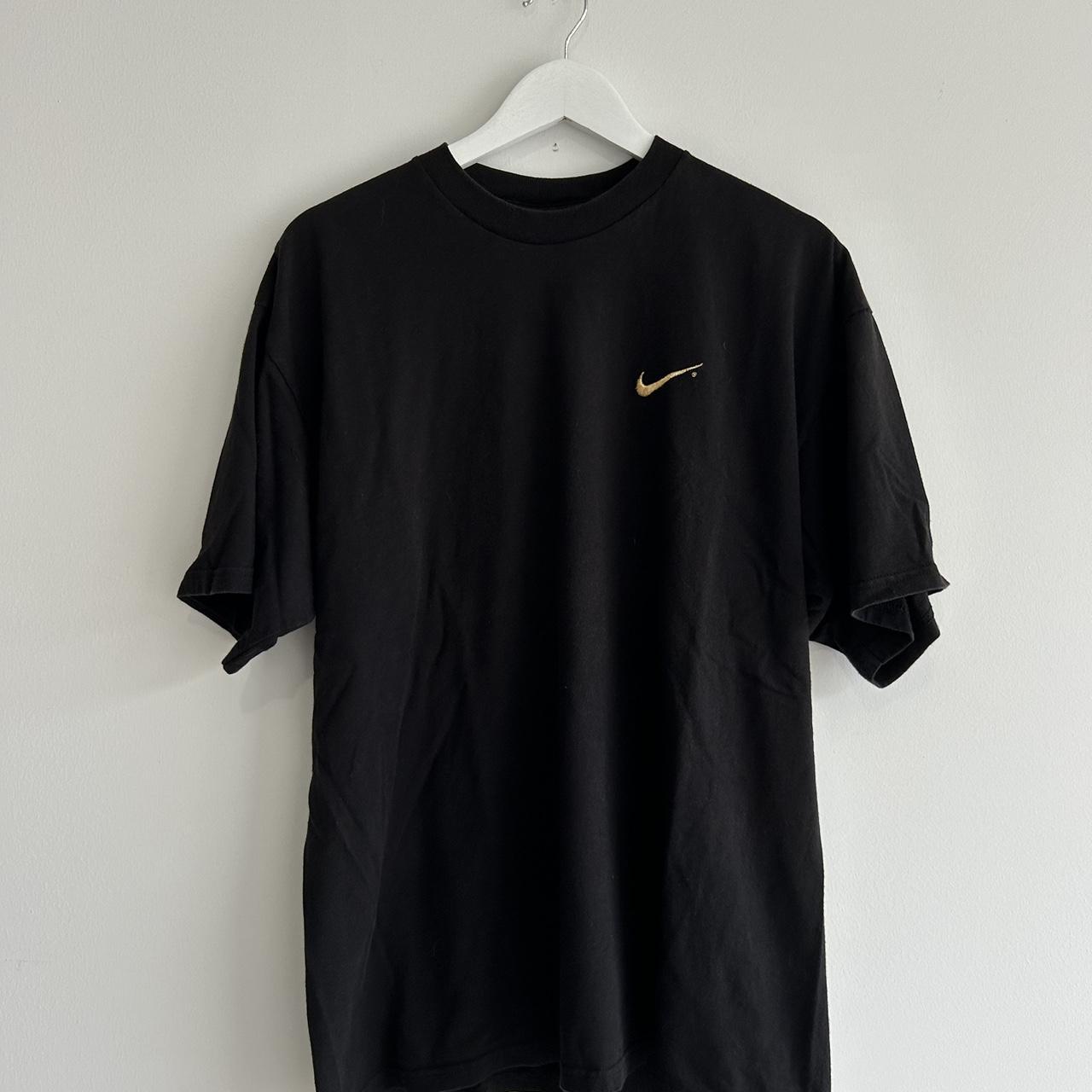 black nike shirt with gold swoosh