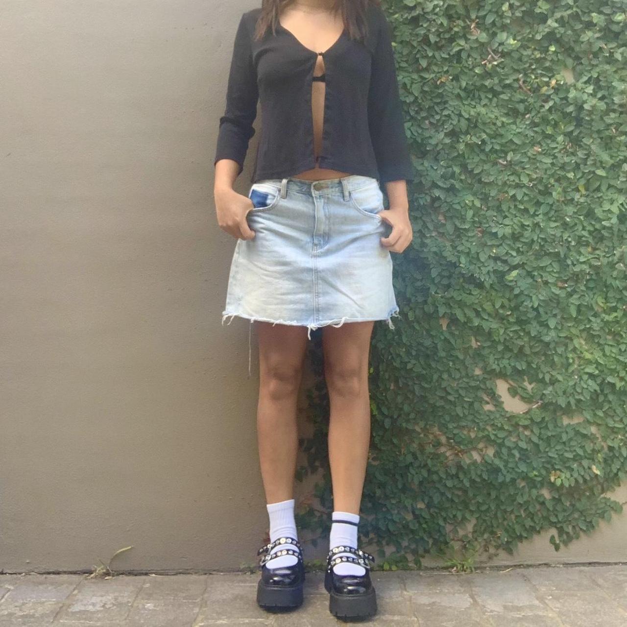 Light blue denim mini skirt with raw hem and