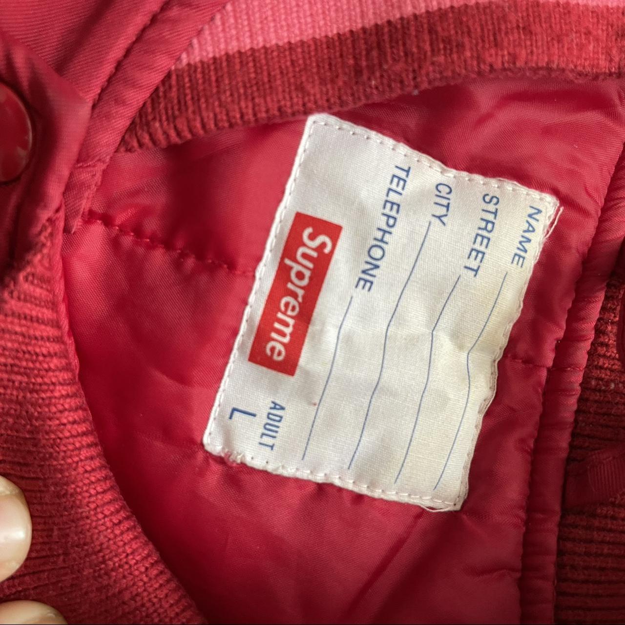 Fashion detail of Supreme red jacket, is seen in the streets of