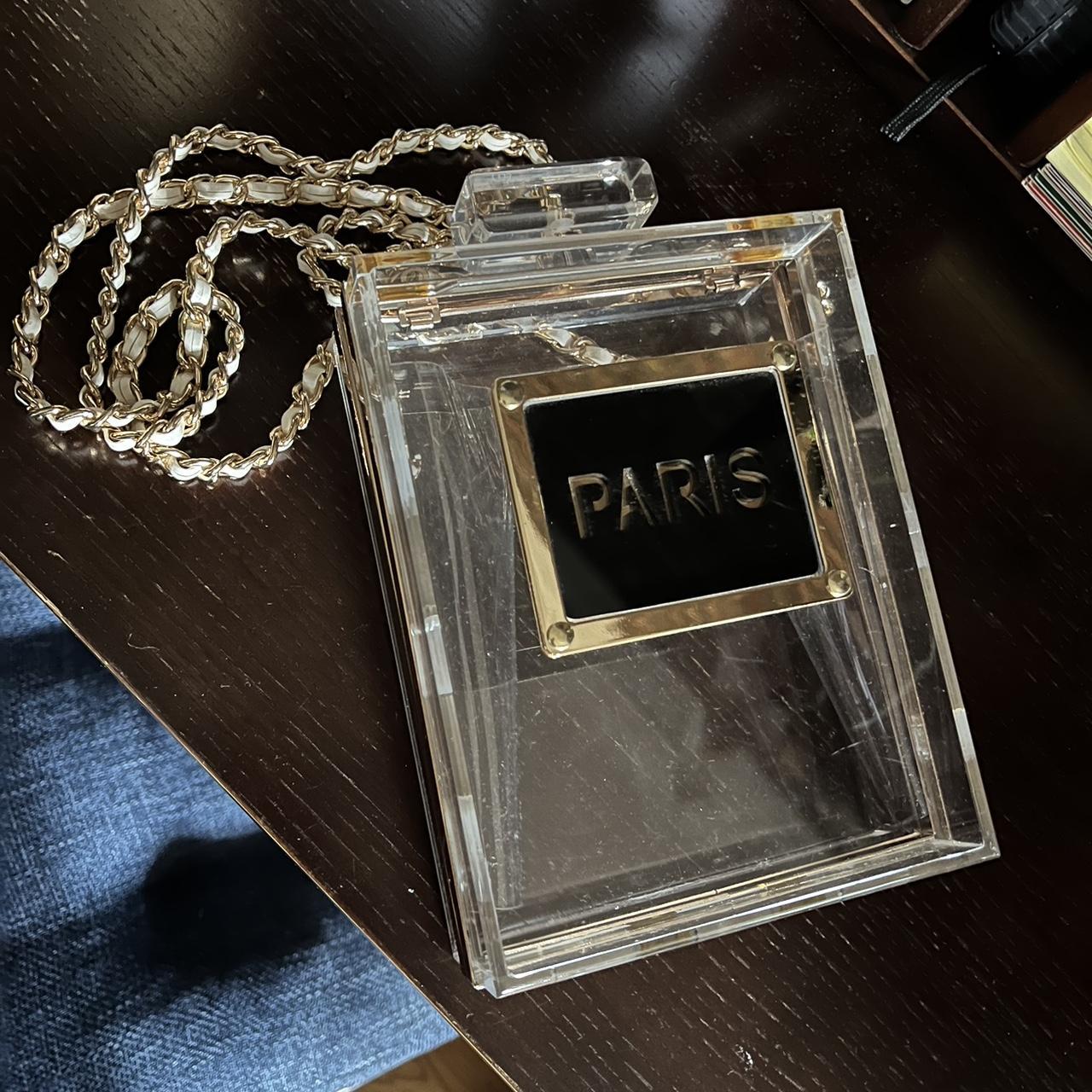 clear perfume bottle purse says PARIS on it. can Depop