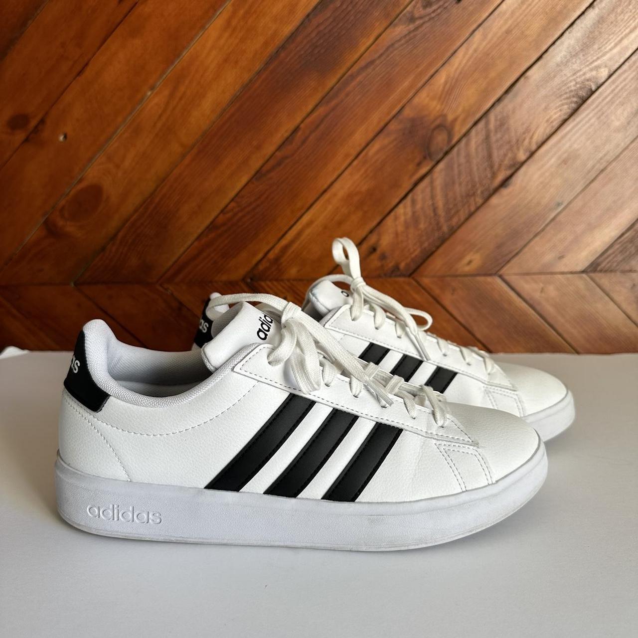 White adidas with black shop stripes on one side