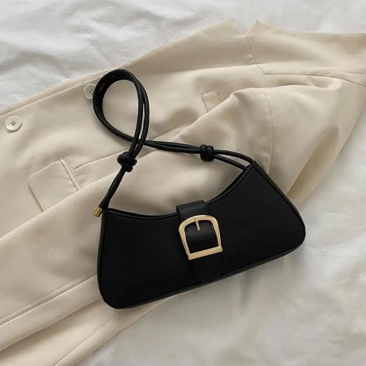 Black shoulder bag with gold buckle and a black... - Depop