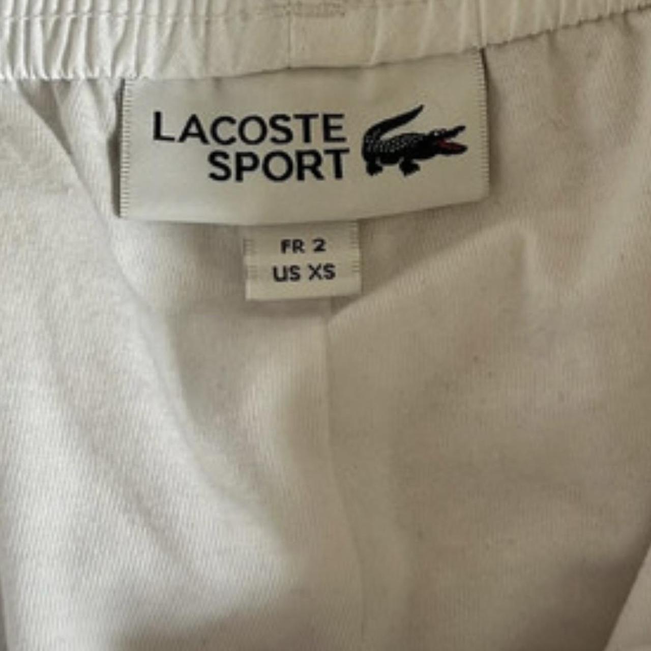 White Lacoste tracksuit bottoms in white old badge... - Depop