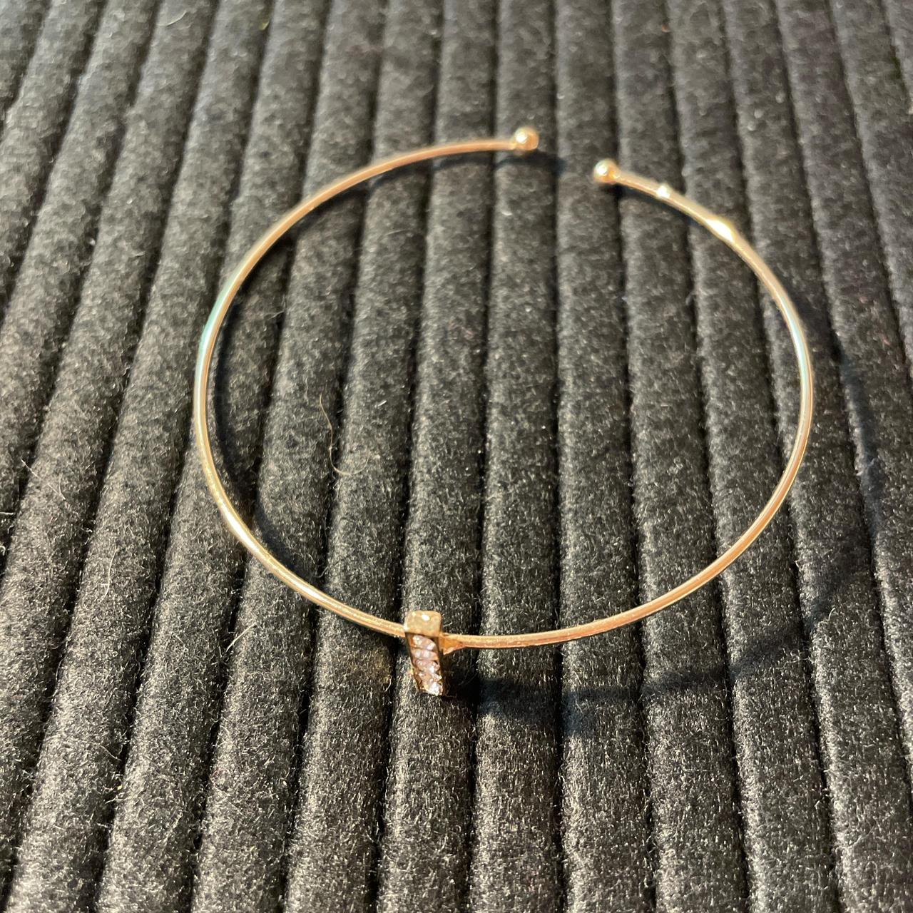 Gold toned bracelet with small rhinestone bar charm.... - Depop