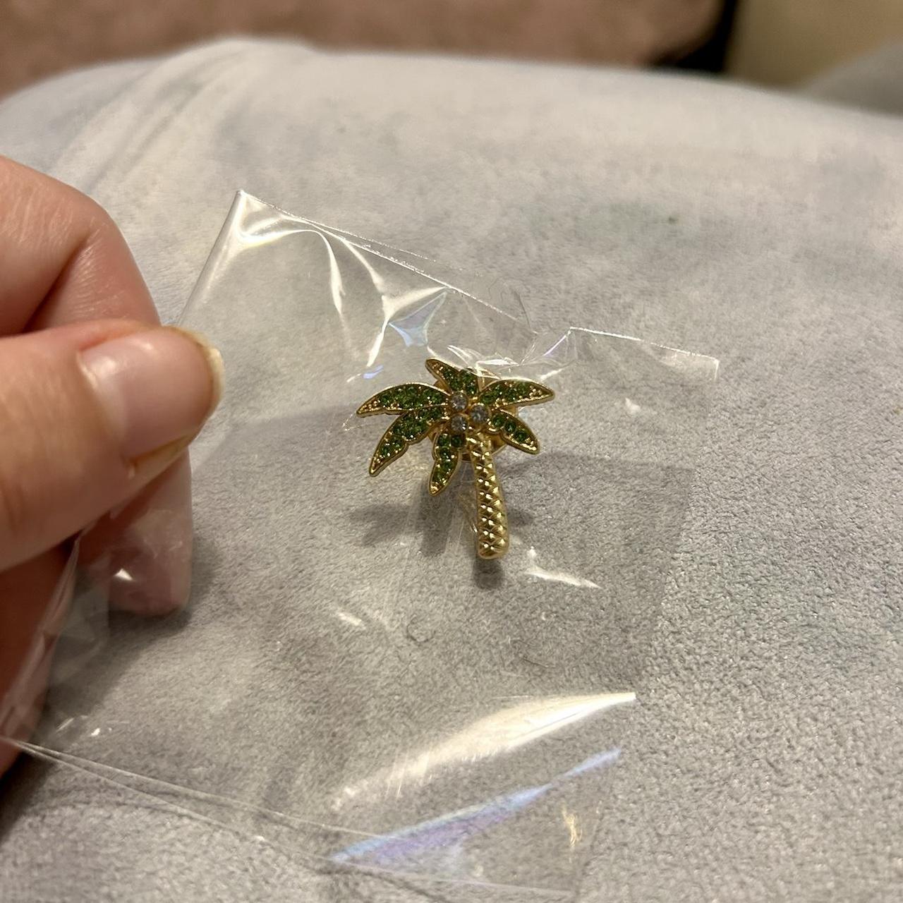 Palm tree pin with rhinestones, featuring a gold and... - Depop
