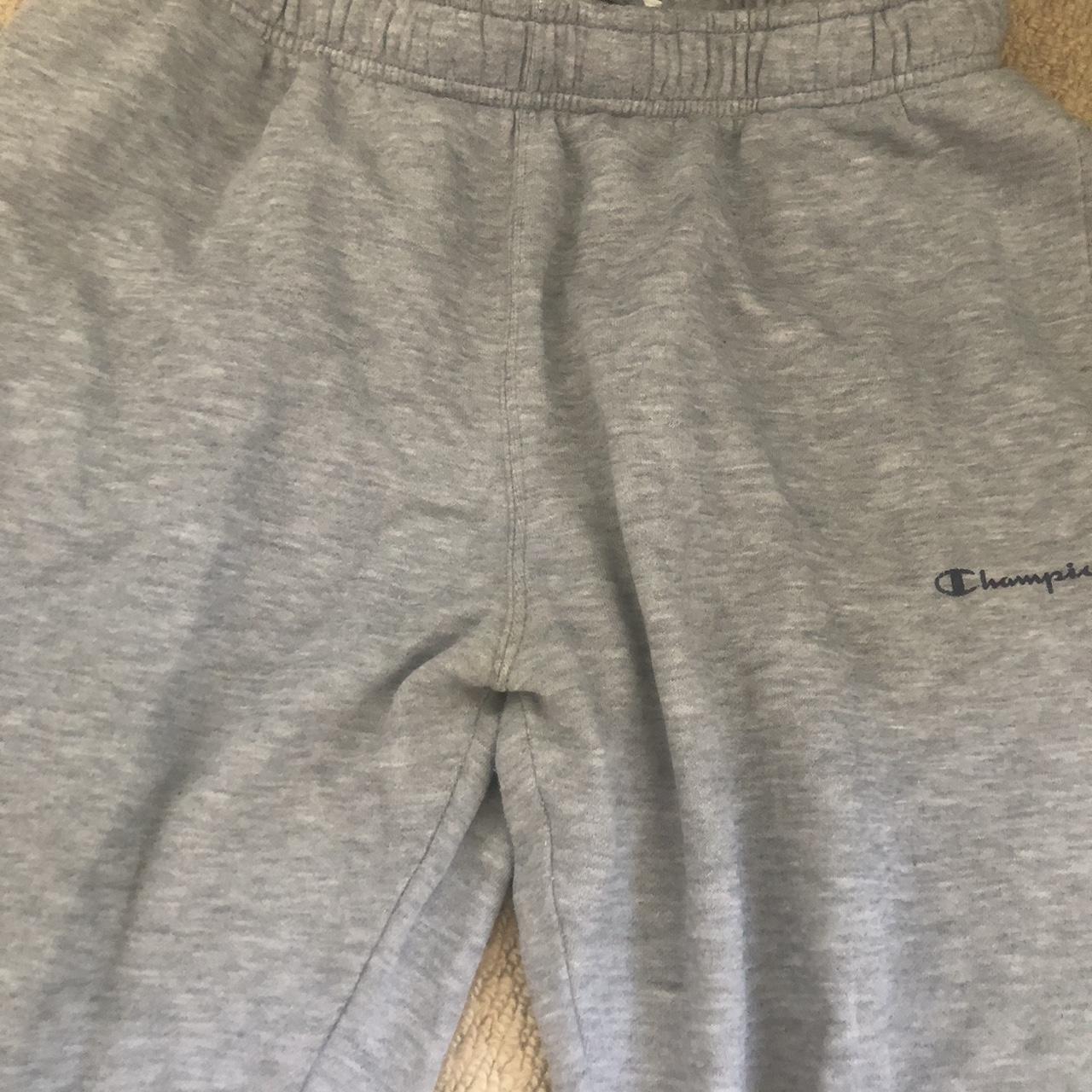 grey champion tracksuit bottoms with small rip in... - Depop