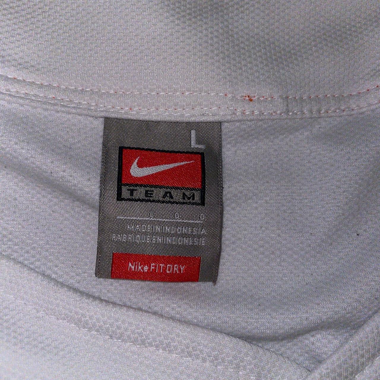 white nike shirt with orange logo