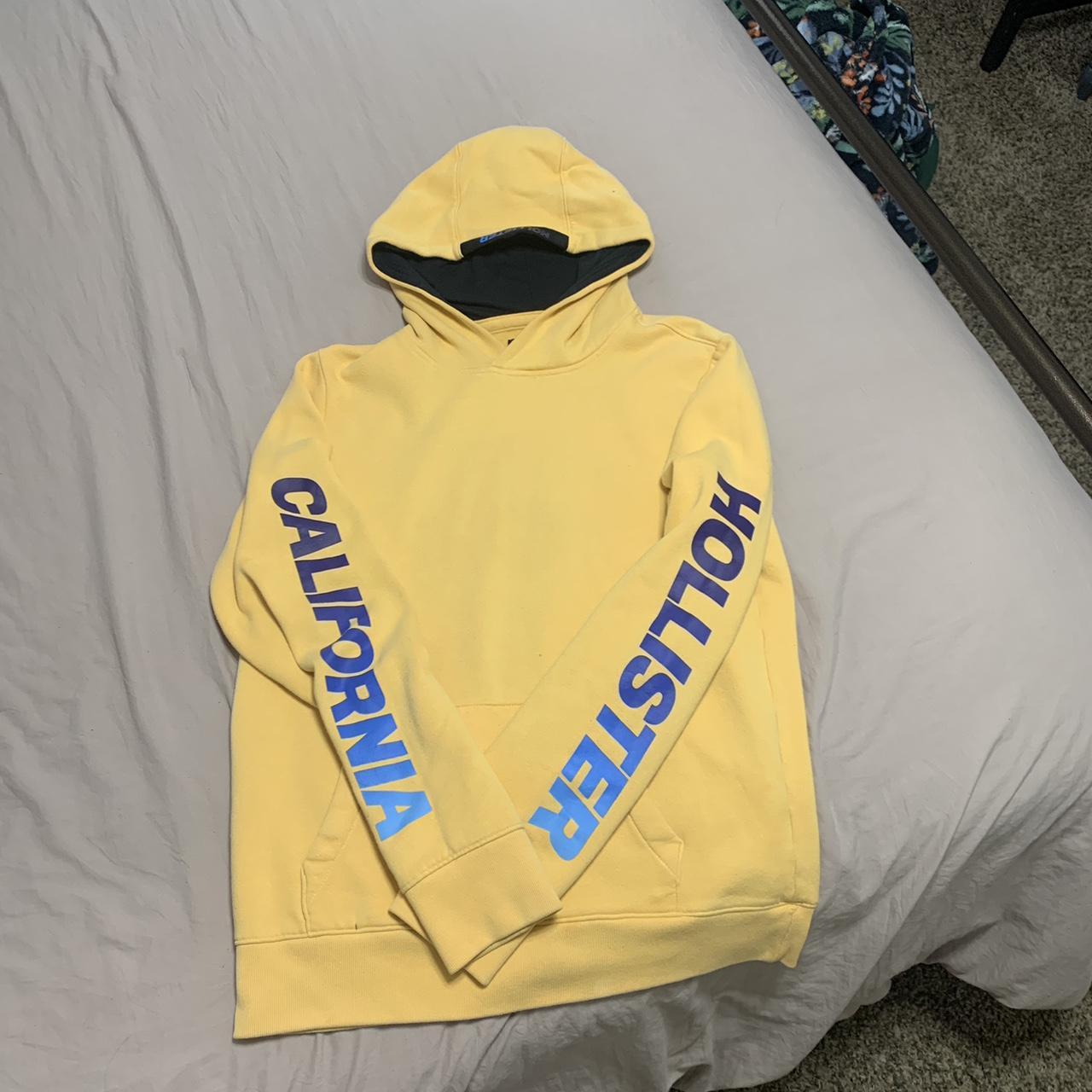 Yellow Hollister hoodie. Blue ombre logo on the... Depop