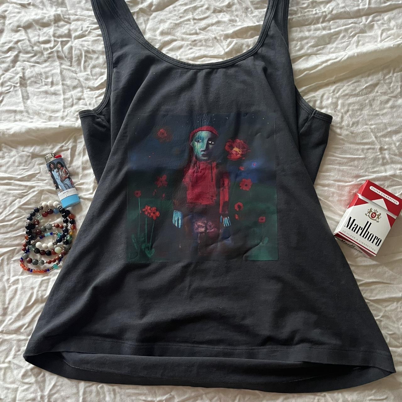 Girl in red Black tank top with a unique graphic... | Depop
