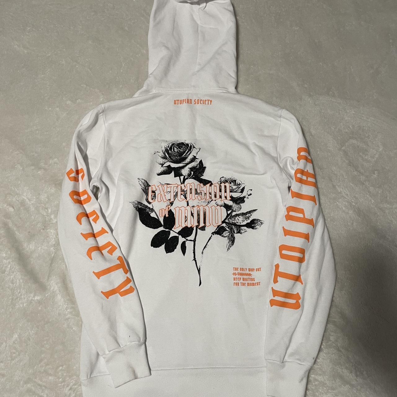 White and orange hoodie with a small tear on Depop