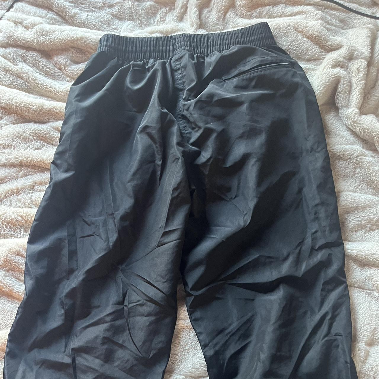 size large black track pants with two white stripes... - Depop