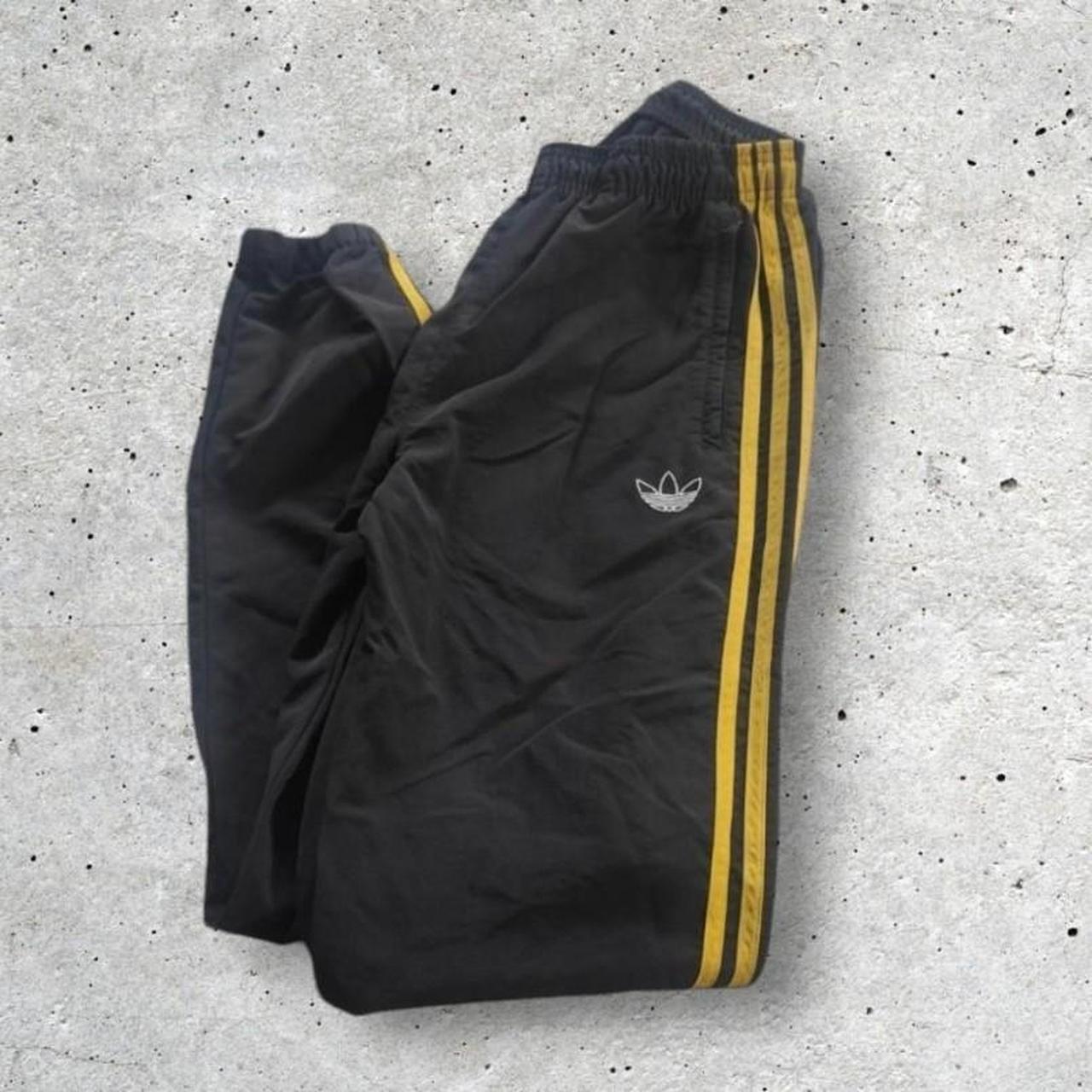 Black adidas pants with yellow stripes best sale