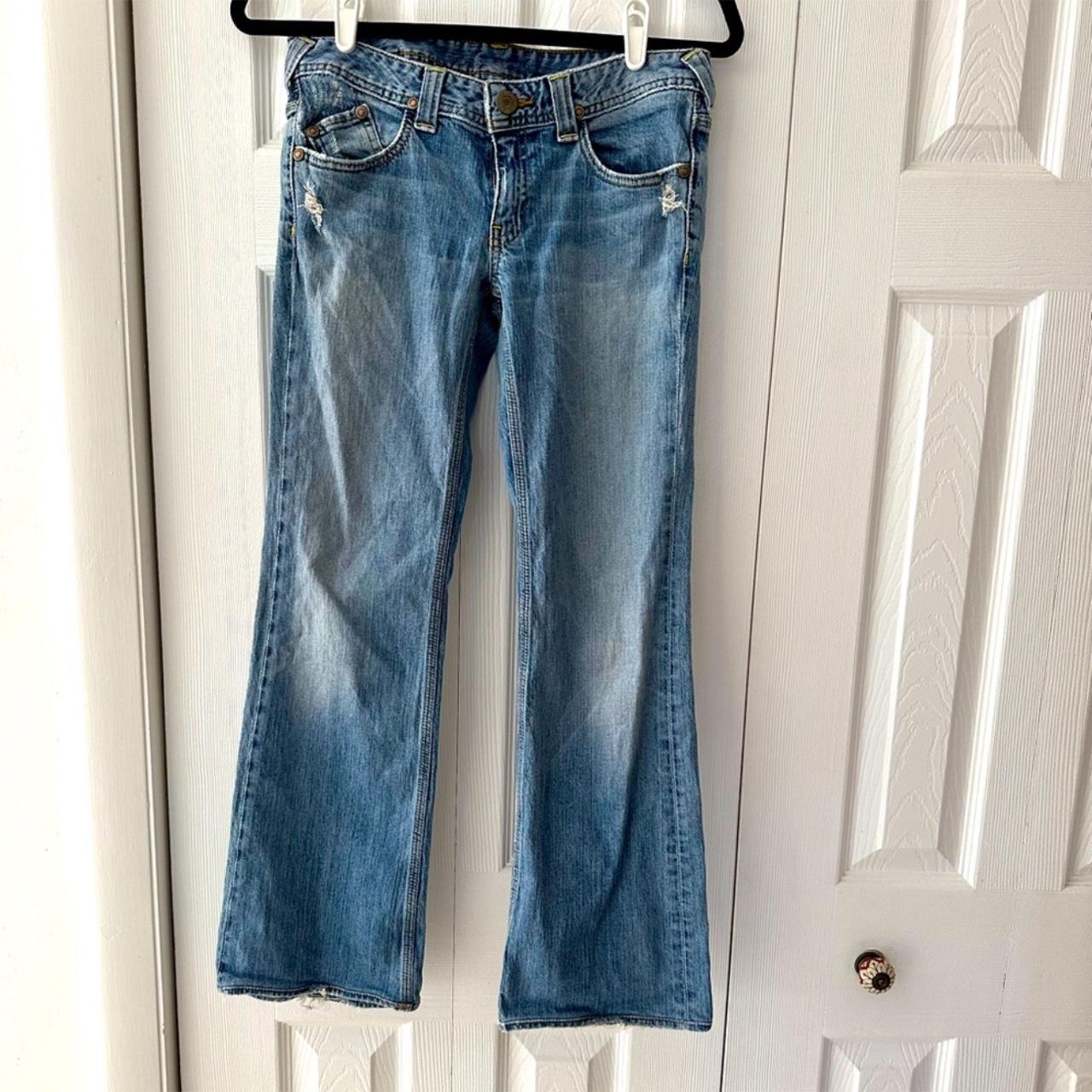 Low rise bootcut blue jeans with distressed details... - Depop