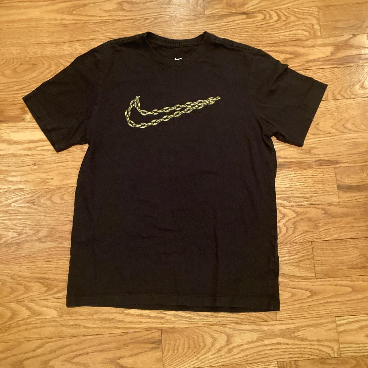 black nike shirt with gold swoosh