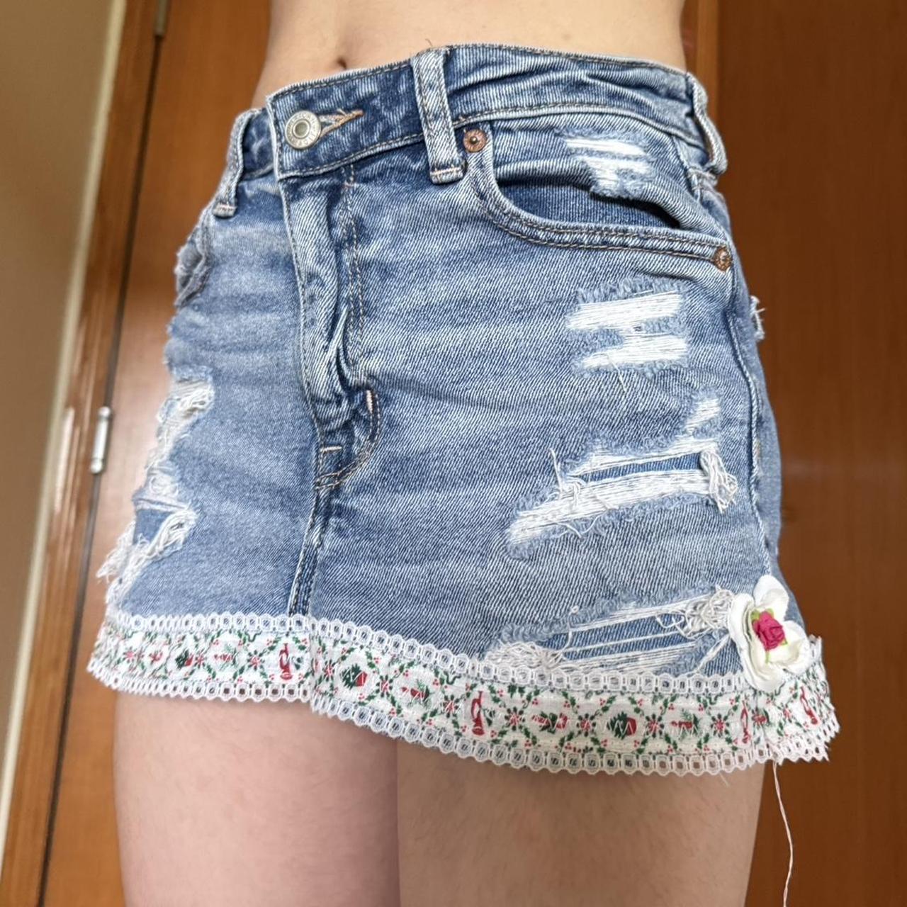 Distressed denim skirt with floral lace, rose, and...