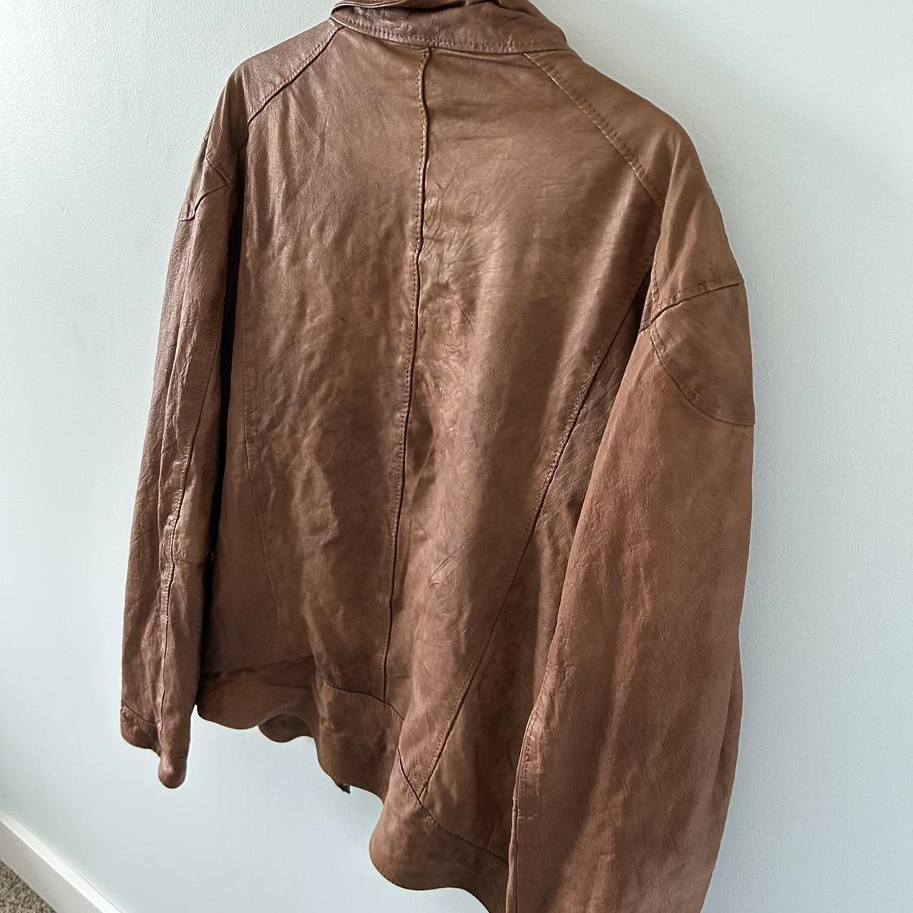 Faux leather brown jacket has a tear above the depop