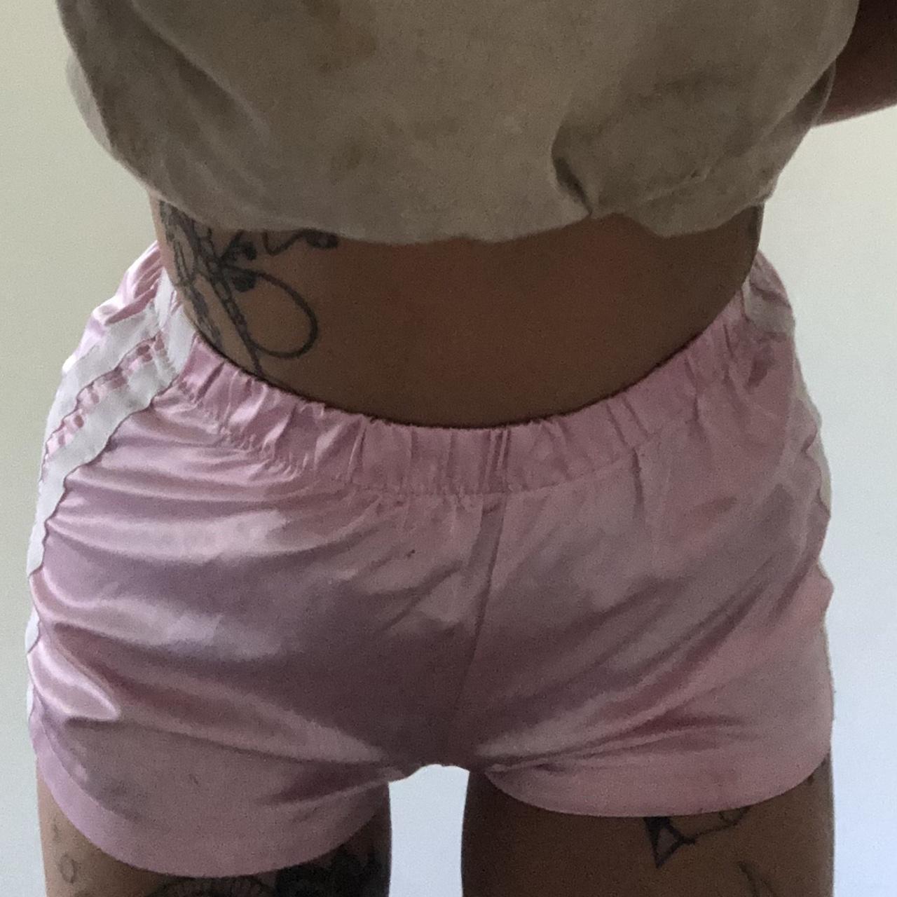 Satin baby pink shorts. Two white stripes down the... - Depop
